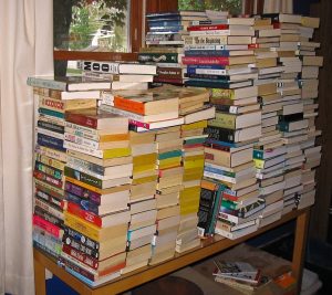 Books piled several feet high, covering a table